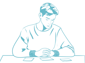 Jahresende ohne Druck: Junger Mensch sitzt am Tisch und sortiert mithilfe von Karten seine Gedanken